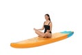 Happy woman practicing yoga on orange SUP board against white background Royalty Free Stock Photo
