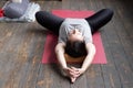 Woman practicing yoga in Reclined Butterfly exercise, supta baddha konasana Royalty Free Stock Photo