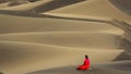 Woman practicing yoga in the sand dunes