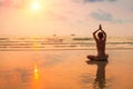 Woman practicing yoga on the sea beach at sunset. Royalty Free Stock Photo