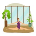 Woman practicing yoga split in front of large window. Indoor peaceful yoga session, home exercise. Health and meditation