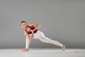 woman practicing yoga, standing in Revolved Side Angle exercise, Parivrtta