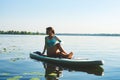 Woman is practicing yoga on a SUP board Royalty Free Stock Photo