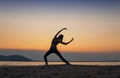 woman practicing yoga during surrealistic sunset at the seaside. Royalty Free Stock Photo