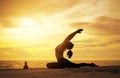 woman practicing yoga during surrealistic sunset at the seaside. Royalty Free Stock Photo