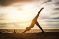 woman practicing yoga during surrealistic sunset at the seaside. Royalty Free Stock Photo