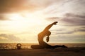 woman practicing yoga during surrealistic sunset at the seaside. Royalty Free Stock Photo