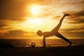 woman practicing yoga during surrealistic sunset at the seaside. Royalty Free Stock Photo