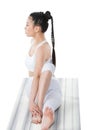 Woman practicing yoga in twisting sage pose Marichyasana on yoga mat