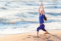 Woman practicing yoga warrior position on the beach Royalty Free Stock Photo