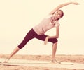 Woman practising yoga poses standing on beach Royalty Free Stock Photo