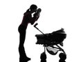 Woman prams holding kissing baby silhouette Royalty Free Stock Photo