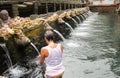 Woman in prayer in holy water at Pura Tirta Empul, hindu temple