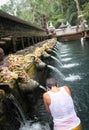 Woman in prayer she wets her head in holy water at Pura Tirta Em Royalty Free Stock Photo