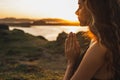 Woman praying alone at sunrise. Spiritual and emotional concept