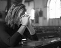 Woman praying in the church grayscale