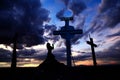 Woman Praying at Cross in Sunset