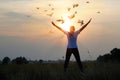 Woman praying and free bird enjoying nature on sunset background, hope concept Royalty Free Stock Photo