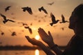 Woman praying and free bird enjoying nature on sunset background, hope concept Royalty Free Stock Photo