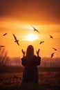 Woman praying and free the birds to nature on sunset background AI generated