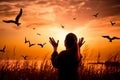 Woman praying and free the birds to nature on sunset background AI generated