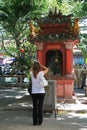 A woman is praying in front of an altar installed in the courtyard of a temple in Saigon (Vietnam)
