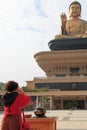 Woman praying the Giant buddha and burning incense at the Fo Guang Shan of Taiwan, Kaohiung
