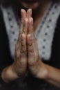 Woman praying with hands together on a dark background Royalty Free Stock Photo