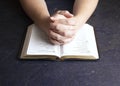 Woman Praying with Her Hands Clasped on a Bible Royalty Free Stock Photo