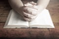 Woman Praying with Her Hands Folded over Her Bible Royalty Free Stock Photo