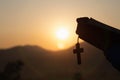 Woman praying while holding Bible and cross, Pray in the Morning , Woman praying with hands together on the Sunrise background Royalty Free Stock Photo