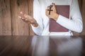 Woman praying while holding Bible and cross, Pray in the Morning , Woman praying with hands together on the Sunrise background Royalty Free Stock Photo