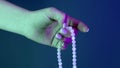 Woman praying and holding mala beads in hand for counts during mantra meditations. Lady on blue background. Spirituality Royalty Free Stock Photo