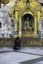 Woman praying inside Shwedagon pagoda in Yangon, Myanmar