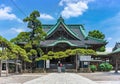 Woman praying in the Japanese buddhist Taishakuten temple overlooked by a pine tree supported by pillars. Royalty Free Stock Photo