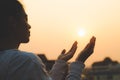 Woman praying in the morning on the sunrise background. Christianity concept. Pray background. Faith hope love concept