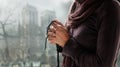 Woman praying with rosary and wooden cross on church background.