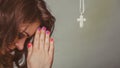 Woman praying to god jesus with cross necklace. Royalty Free Stock Photo