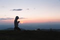 A women is praying to God on the mountain. Praying hands with faith in religion and belief in God on blessing background. Power of Royalty Free Stock Photo