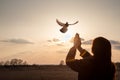 A woman prays a dove flies towards her as a symbol of hope for the peace Royalty Free Stock Photo