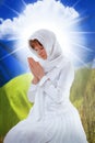 A woman prays on the background of the Ukrainian flag