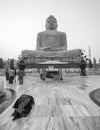 Woman prays on the floor in front of the Great Buddha Statue in Boh Gaya