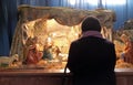 A woman prays in front of the Christmas creches in the Basilica of the Sacred Heart in Zagreb