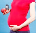 Woman in pregnant with apple and glucose meter with good result sugar level, diabetes and nutrition during pregnancy Royalty Free Stock Photo