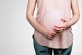 Woman pregnant or bloated belly. Pink balloon in woman& x27;s hands. Abstract background