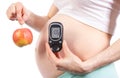 Woman in pregnant with glucometer and apple, diabetes and healthy nutrition during pregnancy Royalty Free Stock Photo