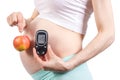Woman in pregnant holding glucose meter and apple, diabetes and healthy nutrition during pregnancy Royalty Free Stock Photo