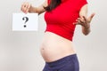 Woman in pregnant holding card with question mark. Expecting birth of boy or girl. Extending family. Motherhood Royalty Free Stock Photo