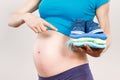 Woman in pregnant showing clothing for newborn, expecting for baby concept Royalty Free Stock Photo