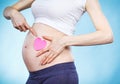 Woman in pregnant showing pink heart on her belly. Expecting for newborn. Extending family Royalty Free Stock Photo